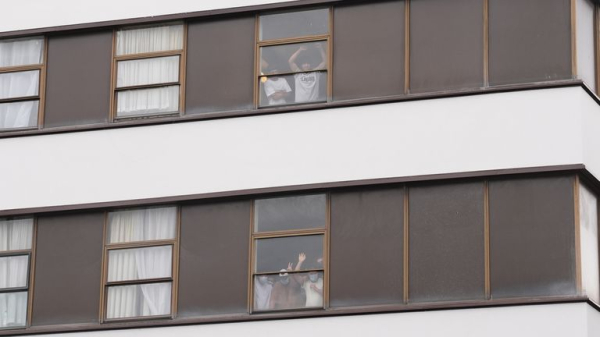 Rival groups face off outside migrant hotel - as asylum seekers 'blow kisses' at protesters