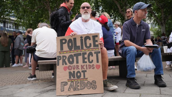 Rival groups face off outside migrant hotel - as asylum seekers 'blow kisses' at protesters